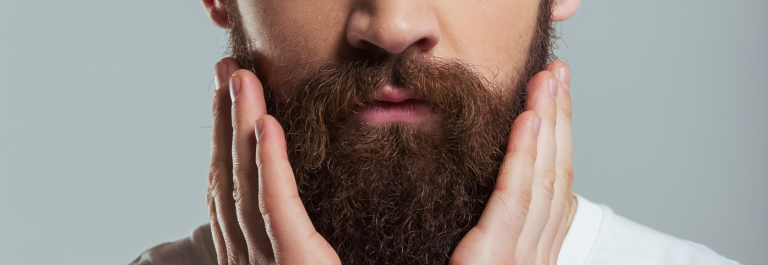 man cupping face and holding beard