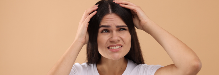 Woman with disgruntled face scratching itchy scalp