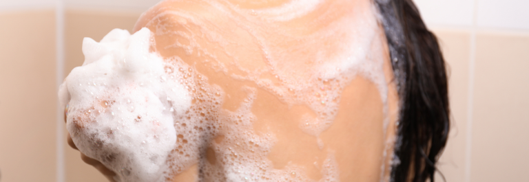 woman lathering soap on arm and back