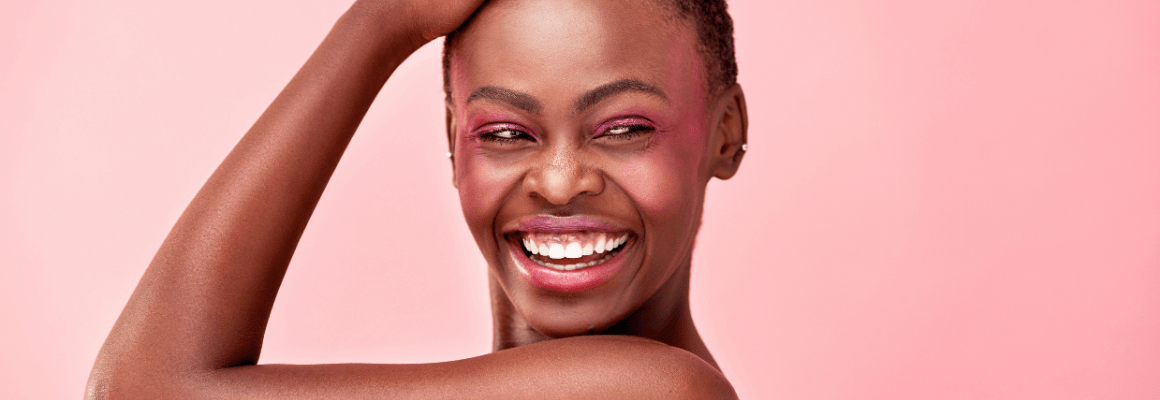woman looking back on pink background - skin positivity