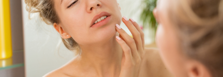 woman picking at face