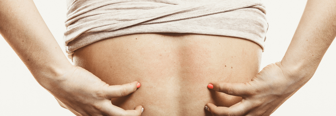 Back Seborrheic Dermatitis - woman scratching her back under shirt