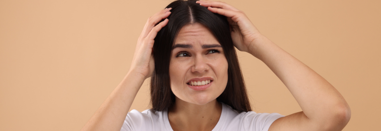 Woman with disgruntled face scratching itchy scalp 