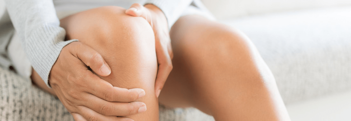 Knee Eczema - woman holding bare knee on couch
