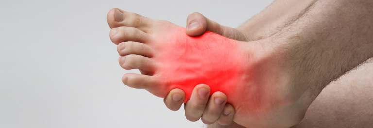 person holding foot with red light to indicate inflammation