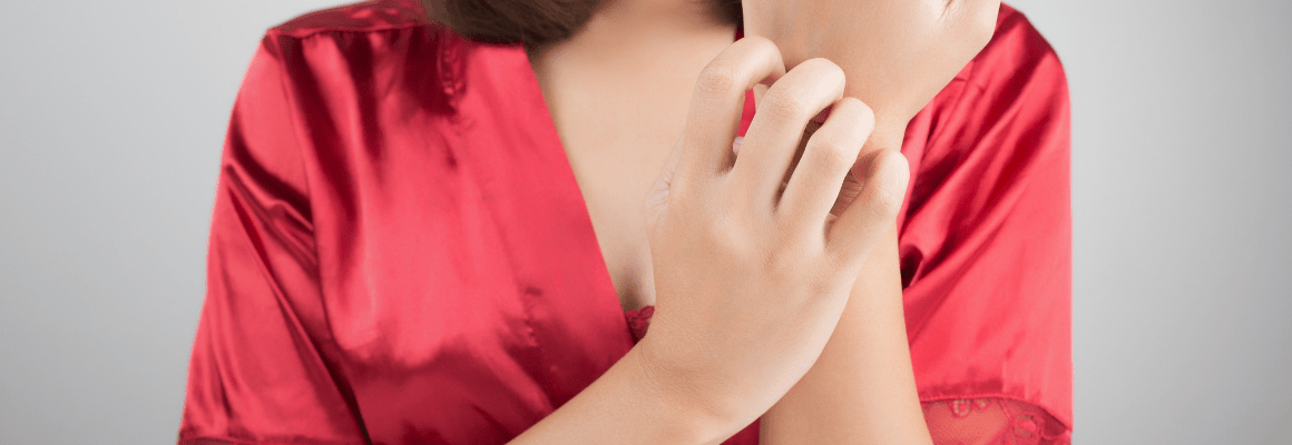 staph infections on skin - woman in red robe scratching hand