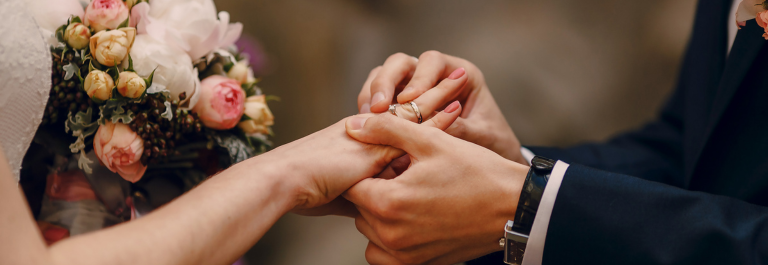 man putting wedding ring rash on woman's finger